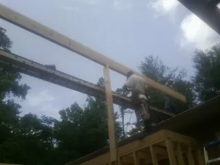Carpenter setting a ridge beam over a new addition frame — Ice Dam Removal by Roofing Brothers in Indianapolis