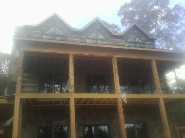Dormers and porch framing on a large log home under construction — Roof Coating work by our crew in Indianapolis