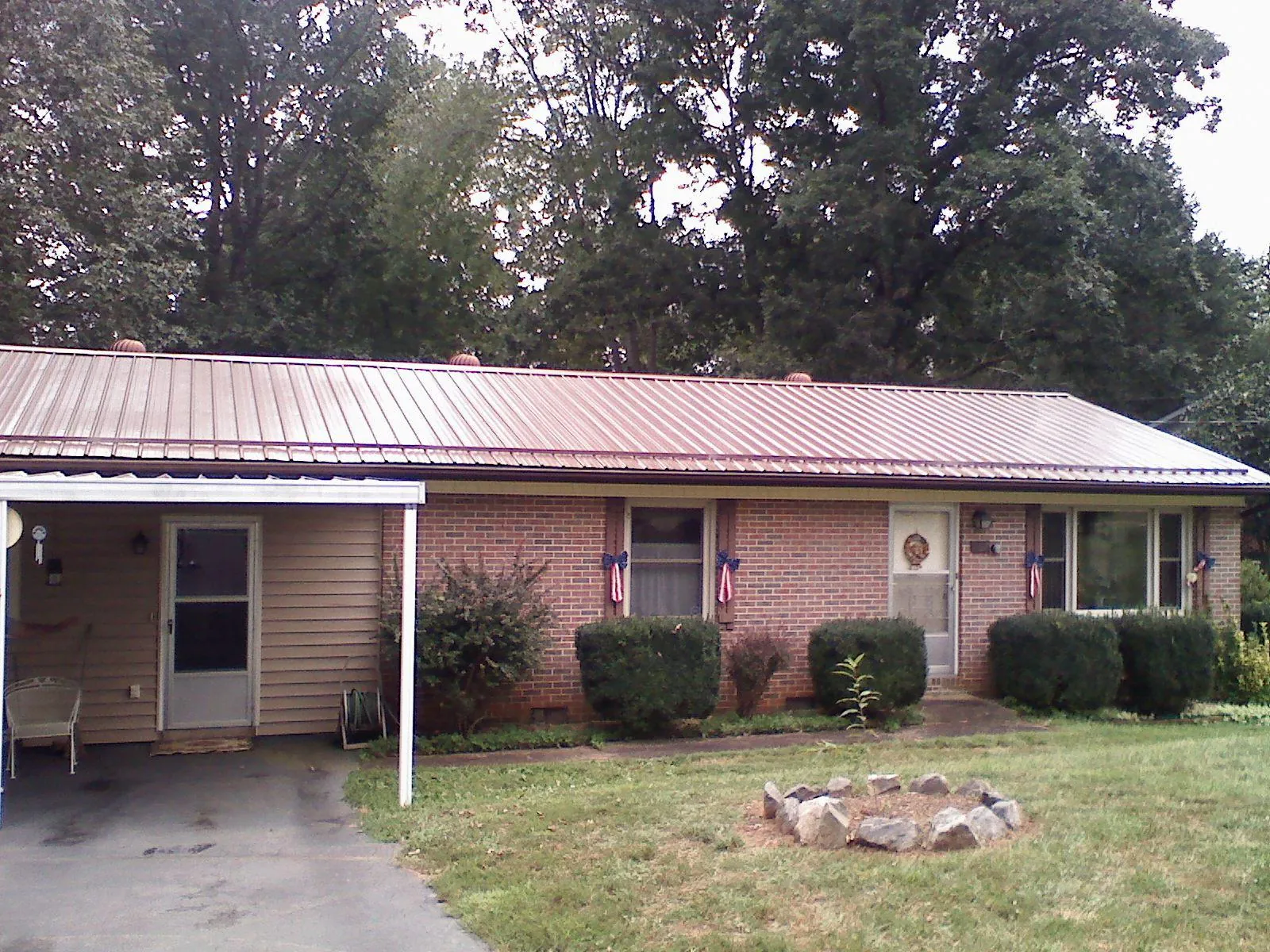 Bronze metal roof and carport on a brick ranch home — Roof Repair work by our crew in Indianapolis