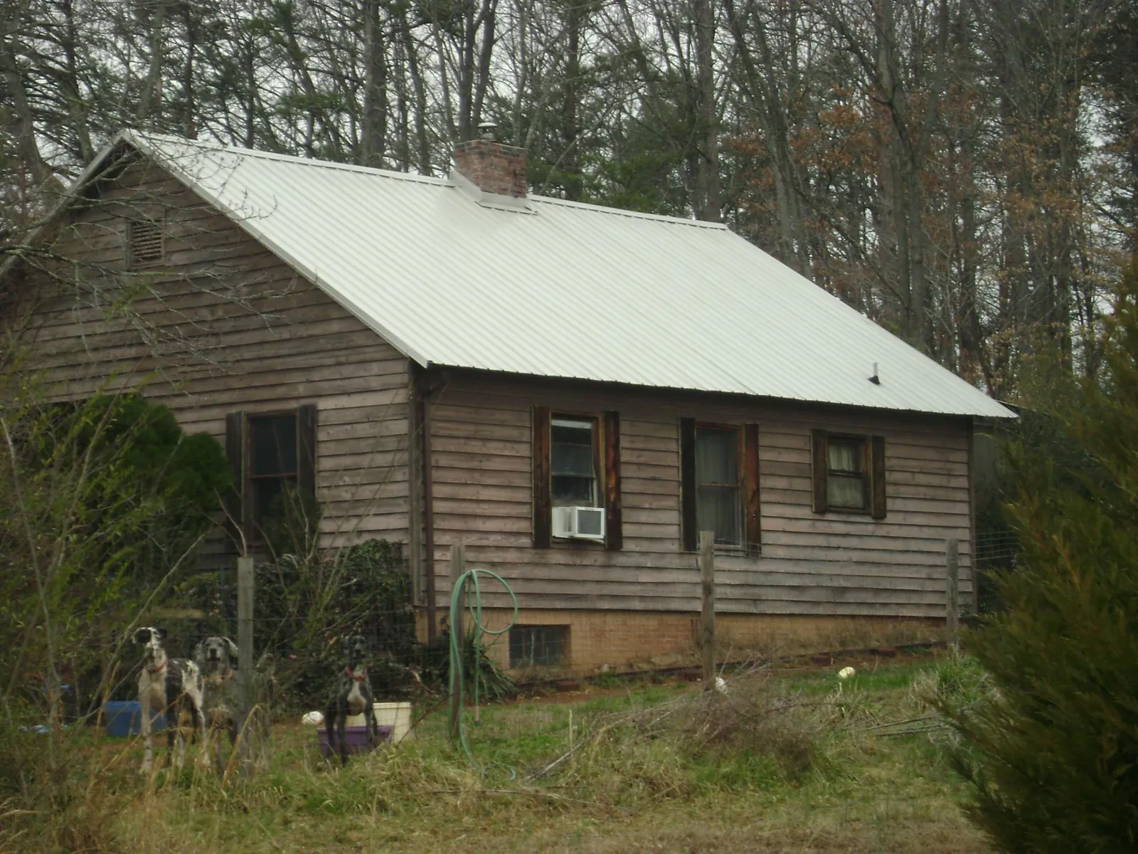 White metal roof on an old wood sided farmhouse, from a Asphalt Shingle Roof Repair job in Indianapolis